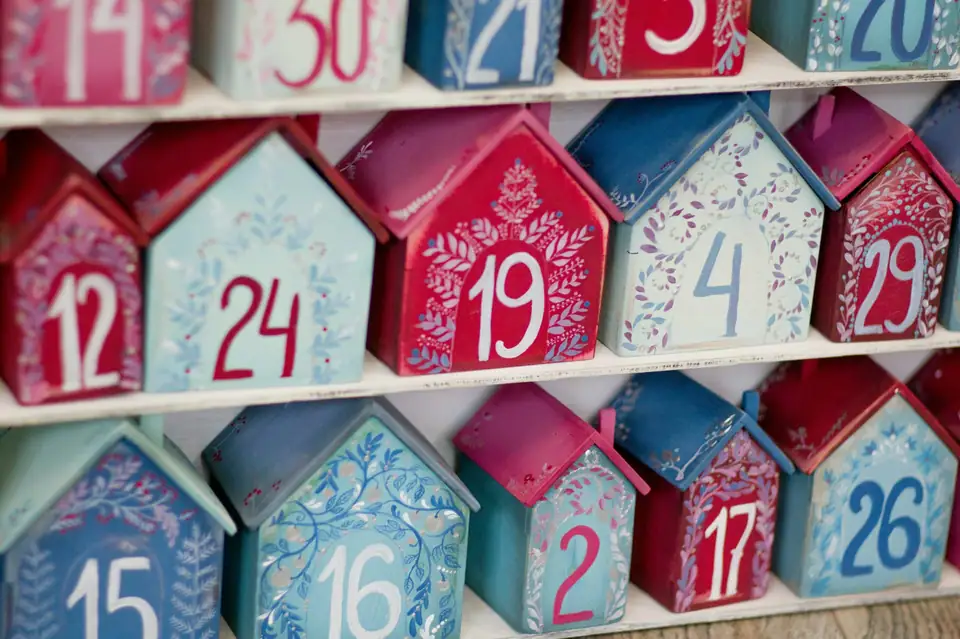 Rows of small paper house boxes in red and blue, each printed with an advent calendar number